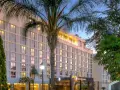 Elegancki hotel w Lusace, stolicy Zambii, otoczony bujną zielenią i palmami.