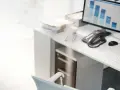 Escritorio con ordenador mostrando gráficos de barras, teléfono, ratón y teclado. La contabilidad y la variacion existencias son clave para analizar estos datos.