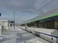 Zimowy peron 2, śnieg i pociąg do Krakowa czekają na pasażerów.