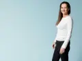 Kvinna i vit tröja och svarta jeans ler mot kameran, redo för en utmaning som fasta 24 timmar.