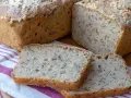 Domowy chleb na zakwasie przepis. Pachnący bochenek z ziarnami, pokrojony na kromki, leży na lnianym ręczniku.