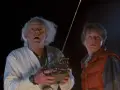 Doc i Marty z "Powrót do przyszłości obsada" z przerażeniem patrzą w niebo, gdy Doc trzyma dziwne urządzenie.