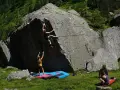 Zwei Frauen klettern an einem Felsen, eine oben, die andere unten. Das ist, was ist bouldern: Klettern ohne Seil an niedrigen Felsen.