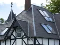 Tetti moderni con tegole scure e lucernari integrati, che valorizzano i materiali e l'architettura della casa.