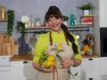 Cristina Catese w kuchni, trzymająca ozdobną dynię i słonecznik.
