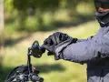 Motociclista con casco integrale obbligatorio e guanti neri, pronto per un viaggio su strada.