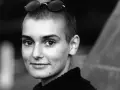 Sinéad O'Connor mit Sonnenbrille auf dem Kopf, ein nachdenklicher Blick. Ihr ikonischer Titel "Nothing Compares 2 U" hallt nach.