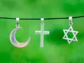 Srebrny półksiężyc, krzyż i gwiazda Dawida wiszą obok siebie. Symbolika islamu, chrześcijaństwa i judaizmu w harmonii.