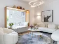 Gemütliche wohnzimmer ideen mit einem bequemen Sofa, einem runden Teppich und einem Fensterplatz.