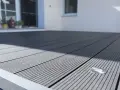 Moderne Terrasse mit grauen WPC Terrassendielen verlegen. Ein kleiner Bodenspot ist integriert.