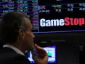 Un hombre observa la pantalla de cotizaciones de GameStop, analizando la previsión de fondos y el comportamiento del mercado.