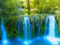Cascata rigogliosa in Toscana, ideale per escursioni nella natura. Acqua cristallina e vegetazione lussureggiante creano uno scenario incantevole.