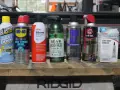 A collection of garage door lube and other lubricants, including Blaster, WD-40, Dupont Silicone, Gear Hugger, Free All, 3-in-One, and Genie Screw Drive Lubricant.
