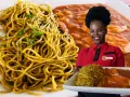 Mujer sonriente con plato de sopa seca y carapulcra.