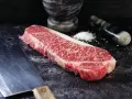 Wyjątkowy stek z krowy wagyu, gotowy do przygotowania. Obok nóż i moździerz z solą.