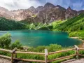 Turkusowe jezioro otoczone zielonymi zboczami gór, przypominające beskidzkie Morskie Oko.