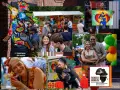 Bunte Kunstfigur und fröhliche Menschen beim **Carnival Berlin**. Ein Mann hält ein Plakat mit der Aufschrift "Danza de Coração".