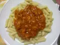 Macarrones con pollo en salsa roja, un plato casero listo para disfrutar.