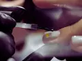Application d'un vernis transparent sur un ongle orné d'un petit cœur jaune. Le base coat, c'est quoi ? C'est la première étape pour une manucure parfaite.