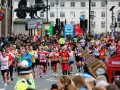 Corredores participan en el maratón de Londres, con Big Ben y cabinas telefónicas rojas de fondo.