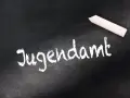 Kreide auf Tafel: "Jugendamt". Eine Empfehlung des Jugendamtes zum Umgangsrecht kann hier notiert werden.