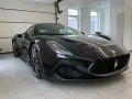 Czarny Maserati MC20 w garażu, widok z przodu.