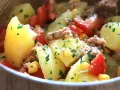 Salade de pommes de terre, thon, tomates et maïs, parsemée de persil frais. Un plat simple et savoureux.