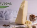 Kawałek sera parmezan, orzechy pekan w szklanej miseczce i liść z napisem FORVEGAN.