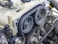 Close-up of a car timing belt system with gears and pulleys. This essential component ensures precise engine timing.
