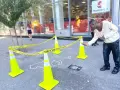 Ein Mann scannt mit seinem Handy einen QR-Code neben einer Kreideumriss-Leiche. Ein cleveres Guerilla-Marketing-Event.