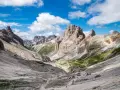 Malownicze **Val di Fassa** w Dolomitach. Kręta ścieżka prowadzi przez skaliste zbocza i zielone hale ku majestatycznym szczytom.