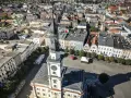Widok z lotu ptaka na rynek w Lesznie. Wieża ratusza góruje nad kolorowymi kamienicami, ukazując urokliwe leszno atrakcje.
