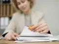 Kobieta przygotowuje dokumenty do odwołania od decyzji ZUS.