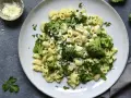 Pasta con brócoli cremosa, espolvoreada con queso rallado y perejil fresco. Un plato sencillo y delicioso.