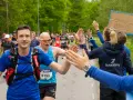 Glada löpare ger high-fives under loppet. Sista veckan innan halvmarathon, peppas deltagarna av publiken.