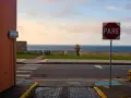 A "PARE" sign stands by the ocean in Puerto Rico. Should I rent a car to explore this beautiful island?