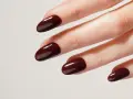 Une idée manucure automne : des ongles courts et arrondis, vernis d'un brun chocolat profond et brillant, évoquant la douceur des feuilles mortes.