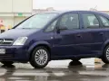 Granatowy Opel Meriva na mokrej nawierzchni. Kierowca w okularach. Wiele pozytywnych opinii o tym modelu.