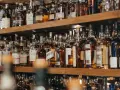 Regale voller Flaschen mit bernsteinfarbenem Whisky oder Whiskey. Eine große Auswahl für Kenner.