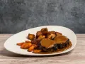Delicioso rabo de toro bañado en salsa, acompañado de patatas rústicas y zanahorias glaseadas.