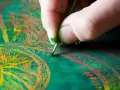 Main d'un artiste peintre travaillant sur une peinture à l'huile aux couleurs vives.