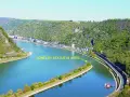 En vidsträckt vy över Loreleis flod, med en stad längs stranden och en järnväg som löper längs floden.