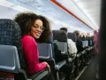 Smiling woman on a discount airlines european flight. She's happy to be traveling affordably.