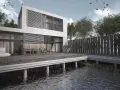 Nowoczesny dom na palach betonowych, z tarasem nad wodą. Drewniane meble ogrodowe i białe pufy zapraszają do relaksu.