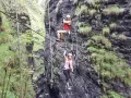 Abenteuer im **Postalmklamm Klettersteig**: Menschen seilen sich durch eine enge Schlucht ab, gesichert an Seilen, umgeben von steilen, bewachsenen Felswänden.