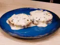 Due medaglioni di filetto al pepe verde, immersi in una cremosa salsa bianca, serviti su un piatto blu.