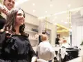 Friseurin stylt lächelnde Kundin mit Lockenstab in modernem Salon.