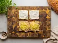Przygotowanie croque madame: na kromkach chleba szynka i ser, na drugiej sos beszamelowy.