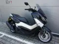 Czarny skuter Yamaha NMAX 125, idealny do miasta. Sprawdź jego dane techniczne i możliwości.