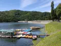 Łódki i rowery wodne czekają na turystów nad jeziorem Rożnowskim. W tle imponująca zapora.